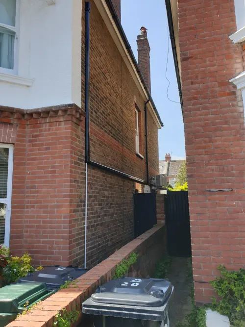 Victorian house with black trunking to condenser
