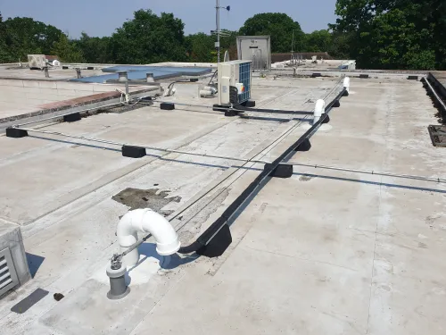Mitsubishi outdoor condenser with anti-vibration pads and pipework in a Kingston home