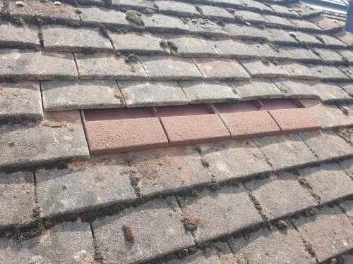 Close-up of Klober Uni Plain tile vent in red granular