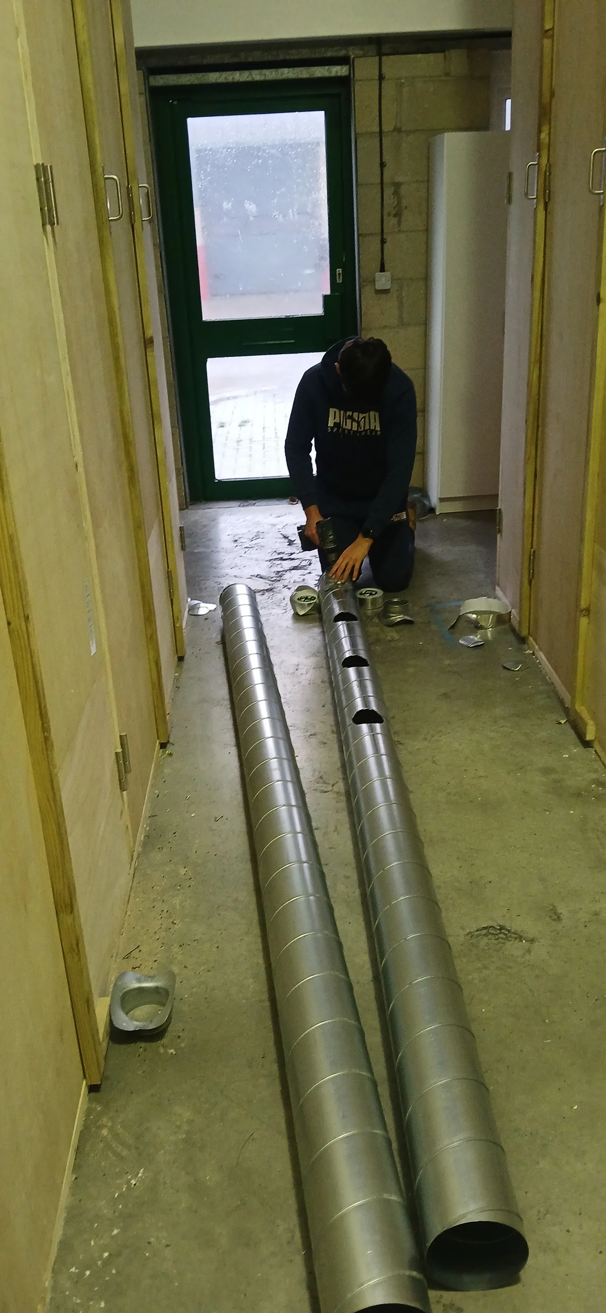 Engineer cutting galvanised spiral ducting during hydroponic climate control installation