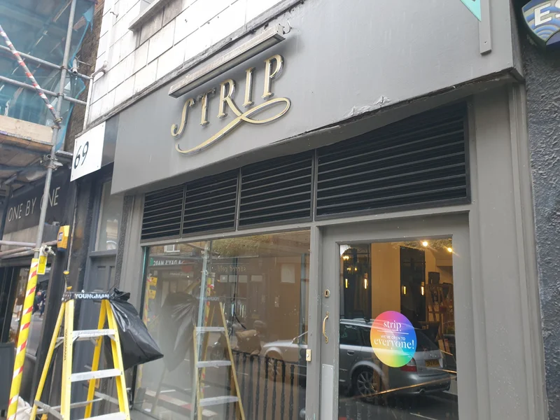 Completed installation showing black louvre grilles integrated above shopfront