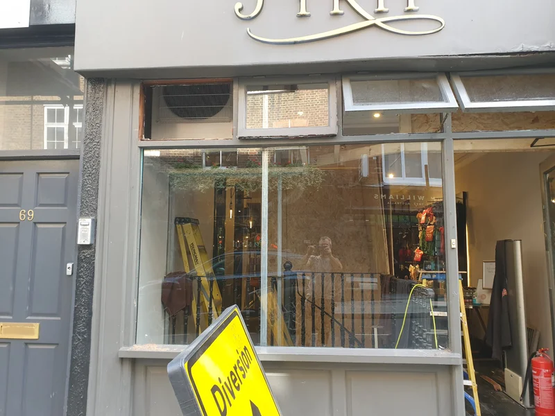 Shopfront during renovation with glazing removed to install AC airflow grilles