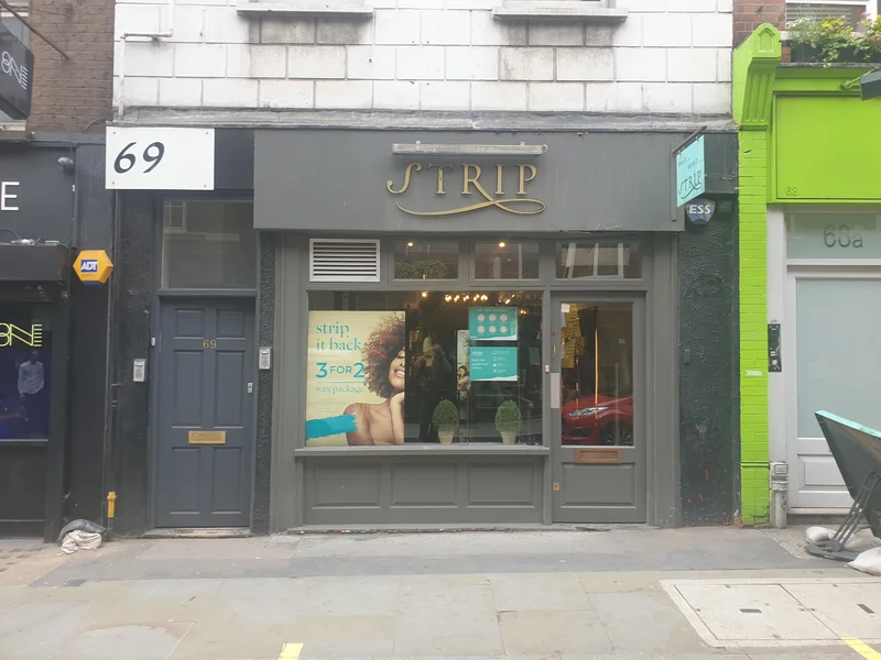 Strip Soho shopfront before renovation showing grey signage and original glazing