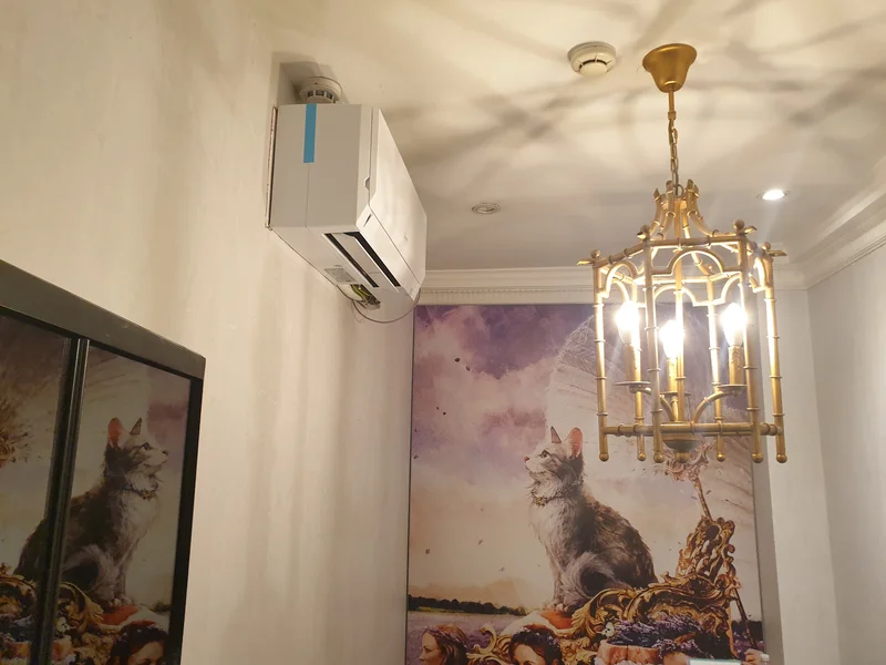 Wall-mounted Mitsubishi AC unit in minimalist white treatment room